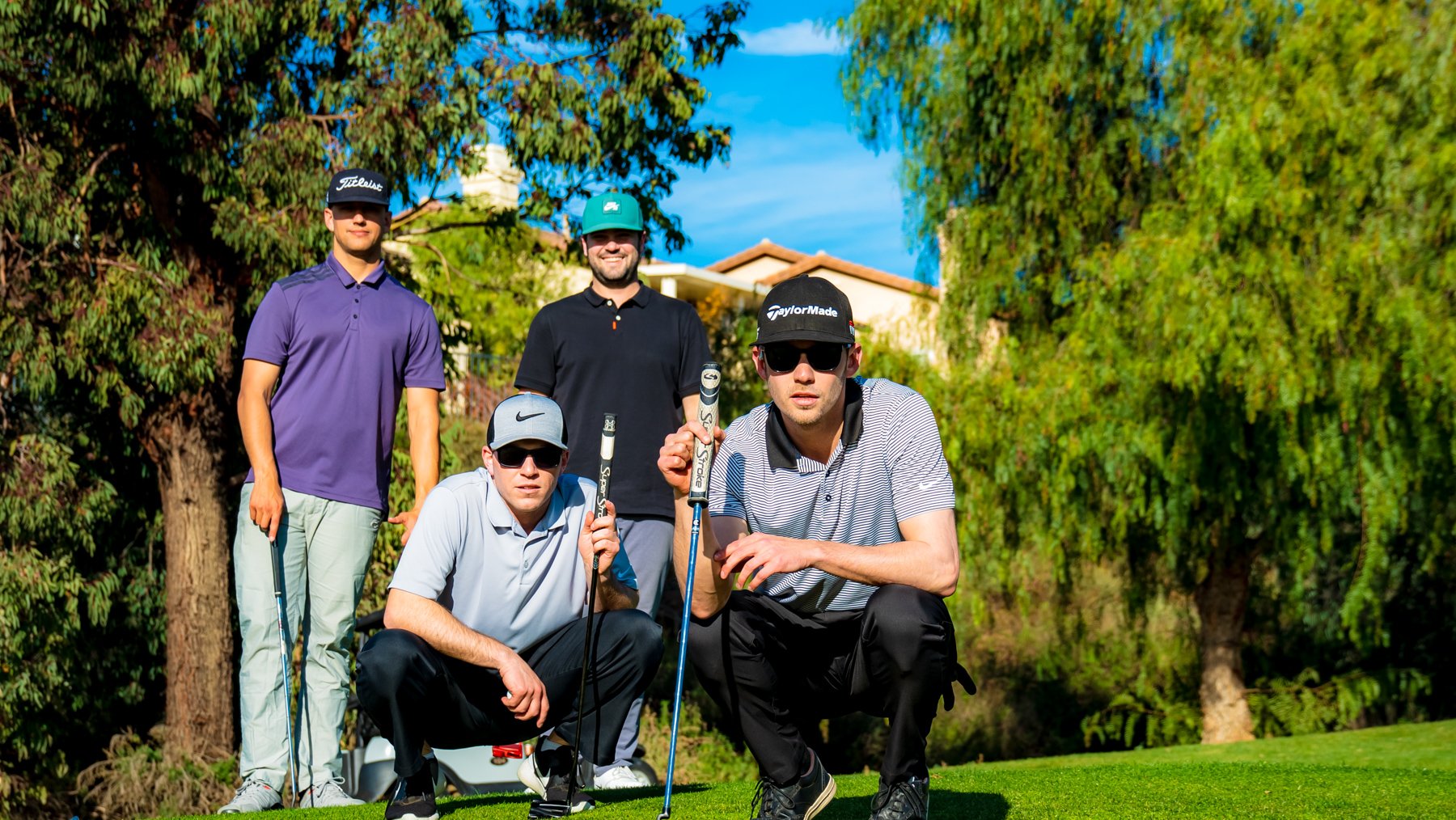 4 male golfers posing